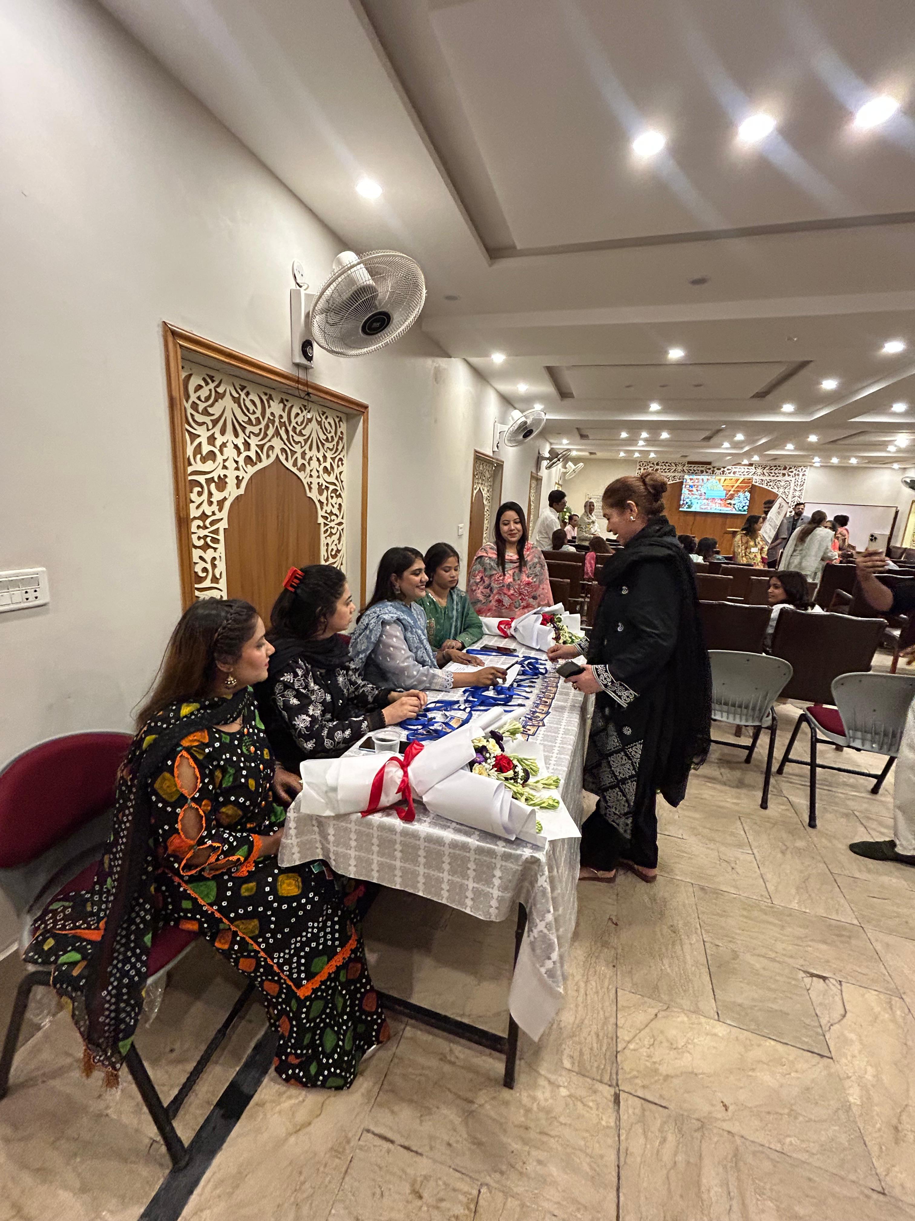 Students greeting one another at the welcome table during Lahore orientation